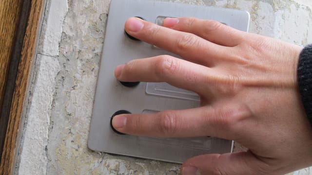 Mann drückt mit mehreren Fingern auf mehrere Türklingeln gleichzeitig. Mann drückt mit mehreren Fingern auf mehrere Türklingeln gleichzeitig.