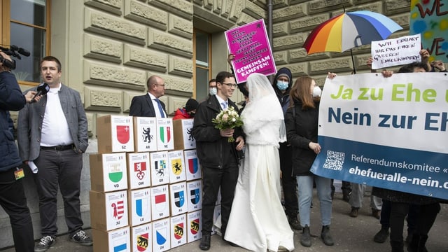 Das Referendumskomitee reicht am 12. April 2021 in Bern die Unterschriften für ein «Nein zur Ehe für alle» ein. Im Hintergrund protestieren die Befürworterinnen und Befürworter der breit abgestützten Vorlage. Das Referendumskomitee reicht am 12. April 2021 in Bern die Unterschriften für ein «Nein zur Ehe für alle» ein. Im Hintergrund protestieren die Befürworterinnen und Befürworter der breit abgestützten Vorlage.