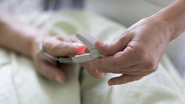 Die Hand einer Patientin und die Hand einer Pflegerin Die Hand einer Patientin und die Hand einer Pflegerin