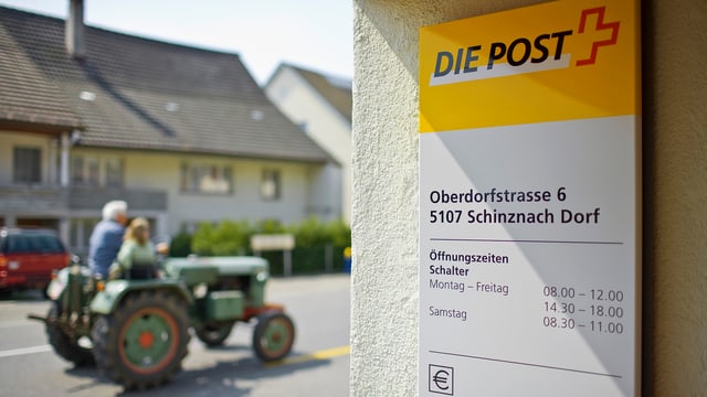 Das Eingangsschild der Posstelle Schinznach Dorf. Im Hintergrund fährt ein grüner Traktor Das Eingangsschild der Posstelle Schinznach Dorf. Im Hintergrund fährt ein grüner Traktor