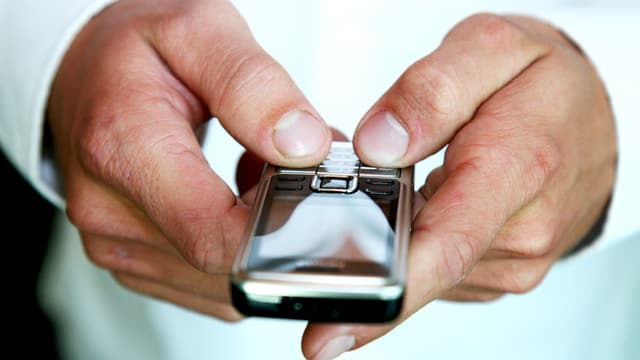 Mann tippt in sein Handy. Mann tippt in sein Handy.