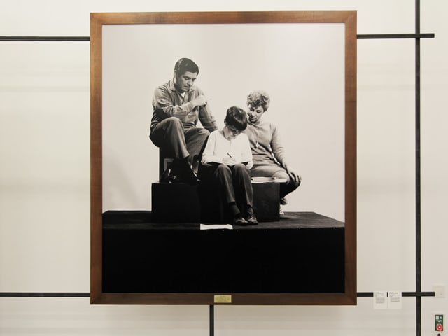 Eine Familie sitzt auf einem Sockel und ist Teil einer Ausstellung. Eine Familie sitzt auf einem Sockel und ist Teil einer Ausstellung.