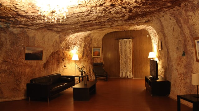 Wohnzimmer in einer Höhle mit Sofa und Fernseher Wohnzimmer in einer Höhle mit Sofa und Fernseher