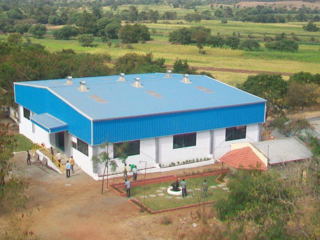 Blick auf die Vigyan Ashram Schule: Ein kleineres Haus, umgeben von Feldern. Blick auf die Vigyan Ashram Schule: Ein kleineres Haus, umgeben von Feldern.