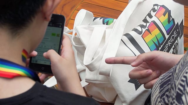 Ein Mann zeigt auf das Smartphone, das ein anderer in der Hand hält. Ein Mann zeigt auf das Smartphone, das ein anderer in der Hand hält.