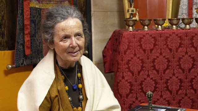 Anne Deriaz sitzt in ihrer buddhistischen Umgebung. Anne Deriaz sitzt in ihrer buddhistischen Umgebung.