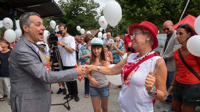 Bundesrat Ignazio Cassis schüttelt die Hand einer Frau Bundesrat Ignazio Cassis schüttelt die Hand einer Frau