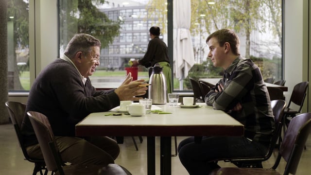 Zwei Männer diskutieren am Tisch. Zwei Männer diskutieren am Tisch.