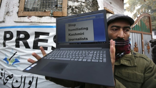 Mann mit Laptop auf dem steht: «stop humiliating kashmiri journalists» Mann mit Laptop auf dem steht: «stop humiliating kashmiri journalists»