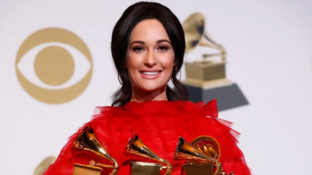 Kacey Musgraves hält drei Grammys in der Hand. Kacey Musgraves hält drei Grammys in der Hand.