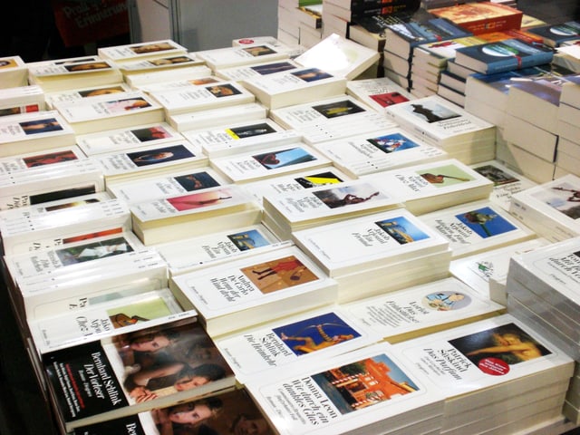 Bücher vom Diogenes-Verlag liegen gestapelt auf einem Tisch. Bücher vom Diogenes-Verlag liegen gestapelt auf einem Tisch.