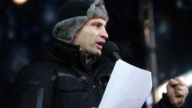 Klitschko mit Fellmütze und einem Manuskript bei seiner Rede. Klitschko mit Fellmütze und einem Manuskript bei seiner Rede.