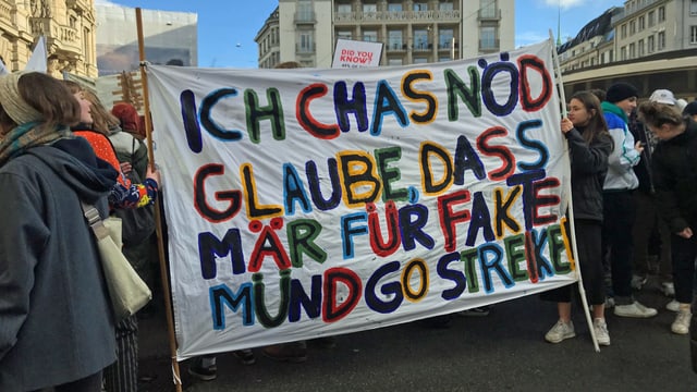 Schüler halten ein Transparent mit der Aufschrift: "Ich cha nöd glaube, dass mir für Fakte müend go streike." Schüler halten ein Transparent mit der Aufschrift: "Ich cha nöd glaube, dass mir für Fakte müend go streike."