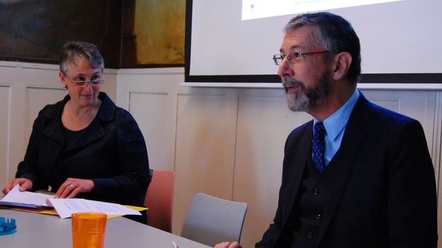 Mann und Frau referieren an einem Tisch. Mann und Frau referieren an einem Tisch.