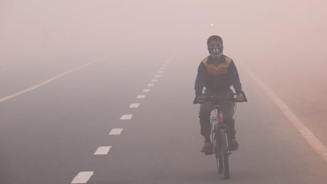 Kind mit Atemmaske auf dem Fahrrad Kind mit Atemmaske auf dem Fahrrad