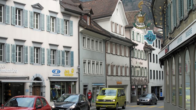 Eine Strasse mit Autos die durch ein Dorf führt, mit alten Häusern rechts und links. Eine Strasse mit Autos die durch ein Dorf führt, mit alten Häusern rechts und links.