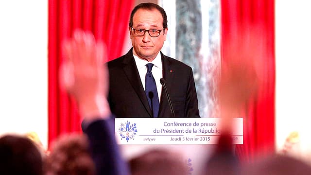 François Hollande an einer Pressekonferenz. Im Vordergrund sind die gereckten Arme von Journalisten zu sehen.