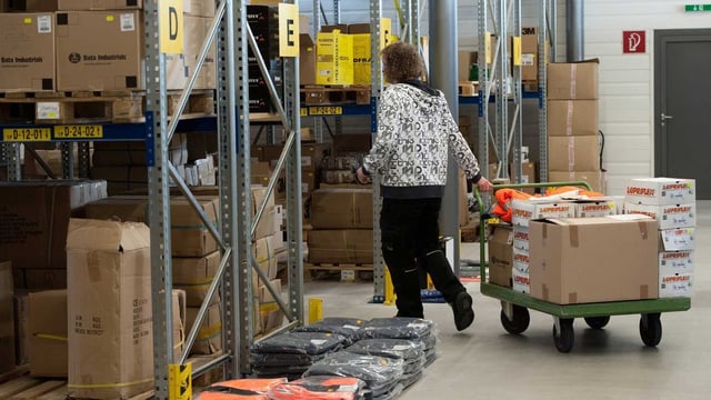 Ein handicapierter Mitarbeiter erledigt Versandarbeiten in einem Lagergebäude. (keystone) Ein handicapierter Mitarbeiter erledigt Versandarbeiten in einem Lagergebäude. (keystone)