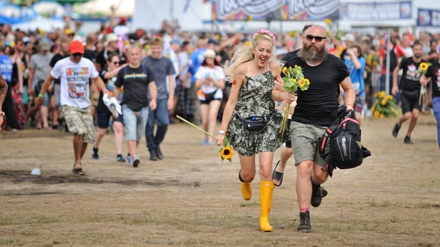 Leute rennen auf einem Festivalgelände. Leute rennen auf einem Festivalgelände.