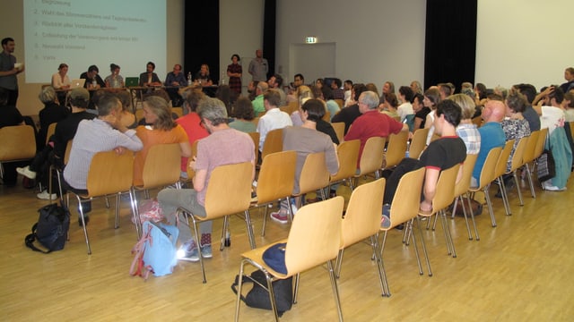 Menschen auf Stühlen in einem Raum. Menschen auf Stühlen in einem Raum.
