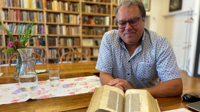 Inhaber Martin von Matt sitzt am Tisch und blickt in eines der über 200'000 wissenschaftlichen Bücher. Inhaber Martin von Matt sitzt am Tisch und blickt in eines der über 200'000 wissenschaftlichen Bücher.