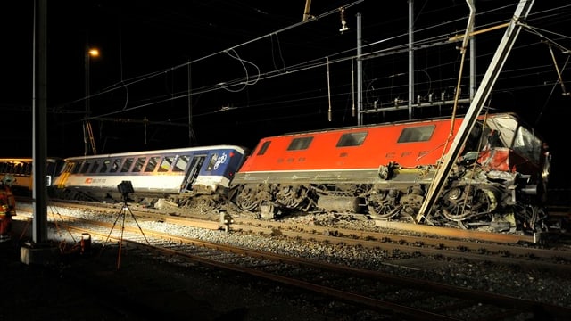 Ein Zugunfall mit einer umgekippten Zugskomposition und einem schräg stehenden Fahrleitungsmast Ein Zugunfall mit einer umgekippten Zugskomposition und einem schräg stehenden Fahrleitungsmast