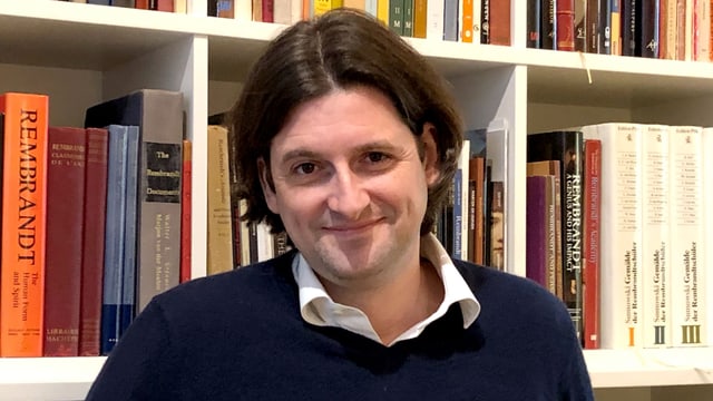 Ein Mann vor einem Bücherregal Ein Mann vor einem Bücherregal