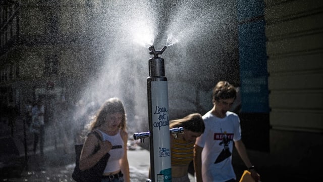 Jugendliche laufen unter einem Wasserstrahl durch. Jugendliche laufen unter einem Wasserstrahl durch.