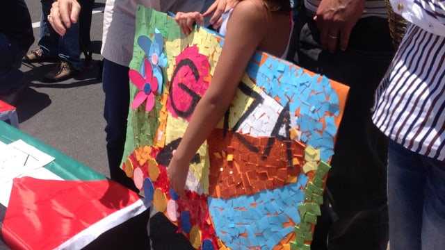 Ein Mädchen hält ein gemaltes Plakat mit der Auffschrift «Gaza» unter dem Arm. Ein Mädchen hält ein gemaltes Plakat mit der Auffschrift «Gaza» unter dem Arm.