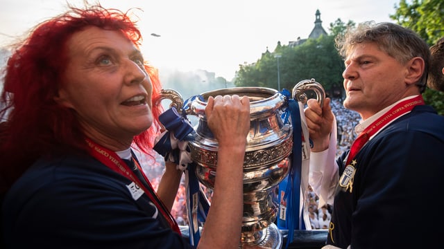 Mann mit Mediaille um den Hals und Pokal in der Hand Mann mit Mediaille um den Hals und Pokal in der Hand