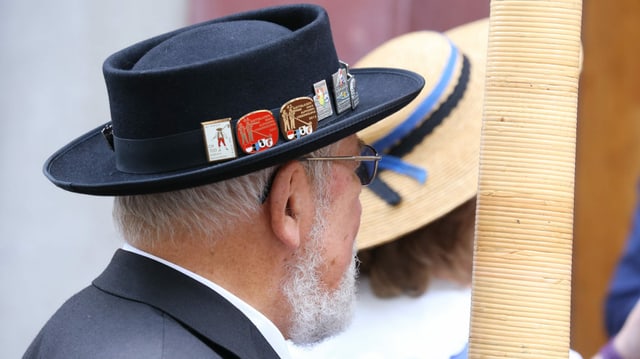 Ein Mann mit einem Alphorn blickt nach vorne. Ein Mann mit einem Alphorn blickt nach vorne.