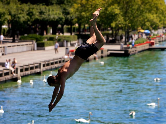 Ein junger Mann "köpfelt" ins Wasser. Ein junger Mann "köpfelt" ins Wasser.