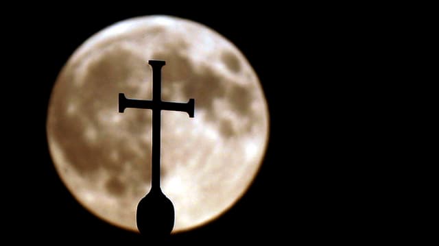Ein Kreuz einer Kirche vor dem Vollmond. Ein Kreuz einer Kirche vor dem Vollmond.