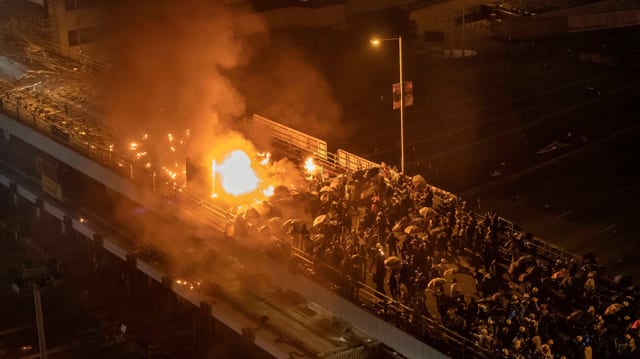 Demonstranten zündeten ausserhalb der Polytechnischen Universität ein Polizeiauto an, auf der Brücke kam es zu Zusammenstössen. Demonstranten zündeten ausserhalb der Polytechnischen Universität ein Polizeiauto an, auf der Brücke kam es zu Zusammenstössen.