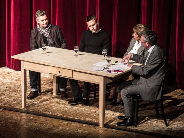 Alle Gesprächsteilnehmer sitzen um einen Tisch.