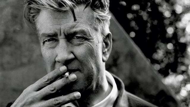 Porträt von David Lynch mit einer Zigarette im Mund. Porträt von David Lynch mit einer Zigarette im Mund.