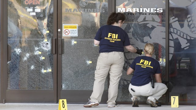 FBI-Mitarbeiter sichern am Tatort Spuren. FBI-Mitarbeiter sichern am Tatort Spuren.