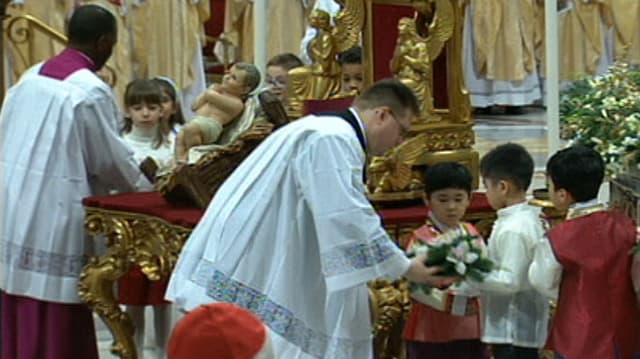 Kinder aus Korea und den Philippinen legen Blumen vor einer Figur des Jesuskindes nieder. Kinder aus Korea und den Philippinen legen Blumen vor einer Figur des Jesuskindes nieder.