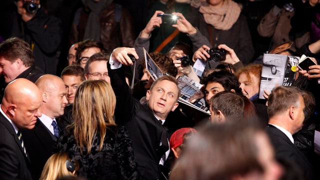 Daniel Craig schiesst in der Menschenmasse ein Foto.