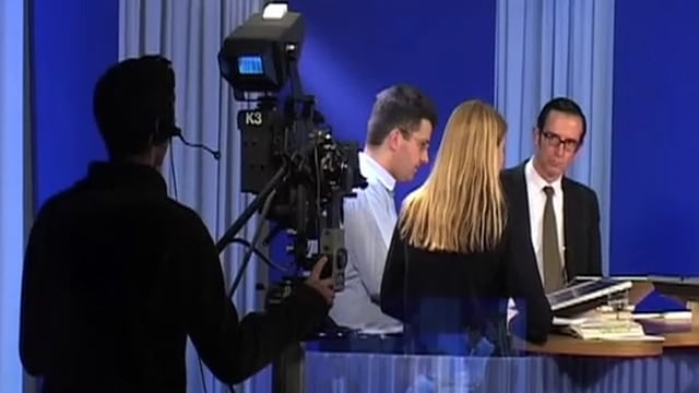 Ein Kameramann filmt drei Menschen um einen Tisch Ein Kameramann filmt drei Menschen um einen Tisch