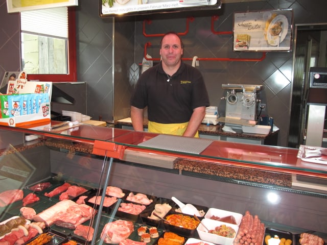 Ein Mann steht hinter eine Fleisch-Theke. Ein Mann steht hinter eine Fleisch-Theke.