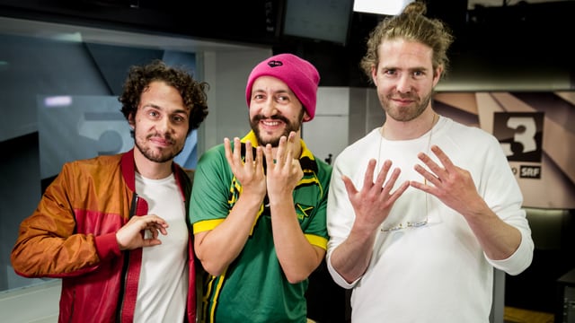 Lo und Leduc sind mit Dr. Mo im SRF 3 Studio und formen mit ihren Fingern die Ziffern 0,7 und 9. Lo und Leduc sind mit Dr. Mo im SRF 3 Studio und formen mit ihren Fingern die Ziffern 0,7 und 9.