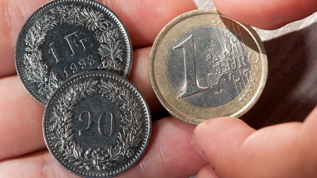 Auf einer Hand liegen ein 1-Franken-Stück, 20 Rappen und 1 Euro. Auf einer Hand liegen ein 1-Franken-Stück, 20 Rappen und 1 Euro.