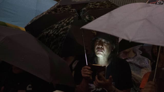 Protestierender in Hongkong mit Smartphone Protestierender in Hongkong mit Smartphone