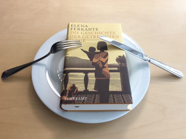 Band 3 Die Geschichte der getrennten Wege von Elena Ferrante liegt auf einem weissen Teller. Messer und Gabel signalisieren, dass Annette König davon nicht genug kriegt. Band 3 Die Geschichte der getrennten Wege von Elena Ferrante liegt auf einem weissen Teller. Messer und Gabel signalisieren, dass Annette König davon nicht genug kriegt.