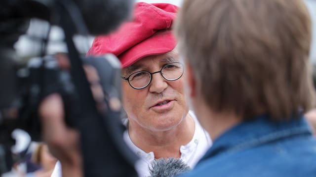 Linard Bardill wird von einem Fernsehreproter interviewt. Linard Bardill wird von einem Fernsehreproter interviewt.