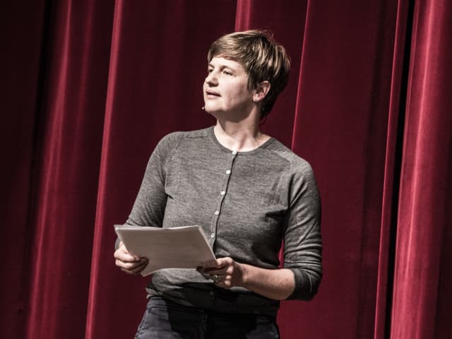 Autorin Sandra Künzi steht auf der Bühne und spricht.