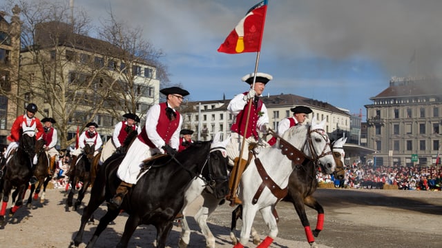Reiter der Zunft Riesbach umrunden mit der Standarte den Böögg Reiter der Zunft Riesbach umrunden mit der Standarte den Böögg