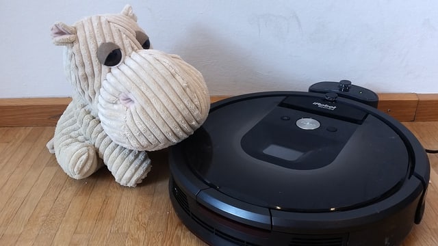 Das Bild zeigt einen aktuellen Staubsauger-Roboter mit einem Stoff-Nilpferd nebendran (dicke Nase!) Das Bild zeigt einen aktuellen Staubsauger-Roboter mit einem Stoff-Nilpferd nebendran (dicke Nase!)