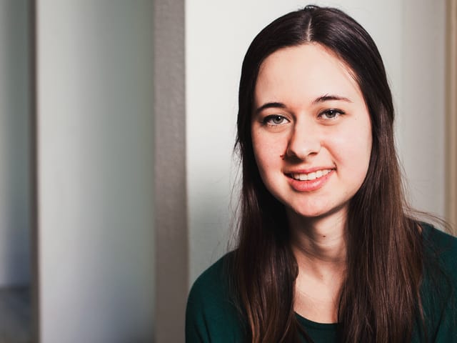 Eine junge Frau lächelt in die Kamera. Eine junge Frau lächelt in die Kamera.